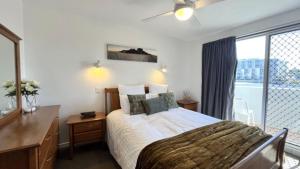a bedroom with a bed and a large window at Pumicestone Chase Unit 5 in Caloundra +6 photos