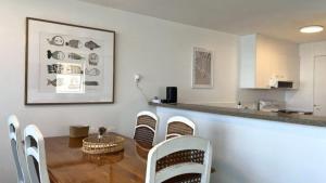 a dining room with a table and chairs and a counter at Pumicestone Chase Unit 5 in Caloundra