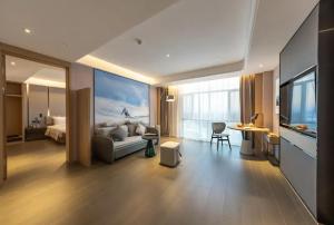 a hotel room with a bed and a table and a desk at Atour Hotel Altay in Altay