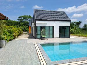 a house with a swimming pool in front of a house at Thegrandstargoodview in Ban Na