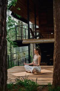a woman sitting on a deck in meditation at Kaya Retreat in Diyatalawa