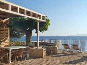 a patio with a table and chairs and the ocean at Dimitra's Studios in Stoupa