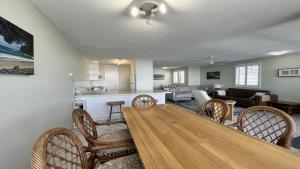 a dining room and living room with a table and chairs at Absolute Waterfront With Rooftop! in Caloundra +9 photos