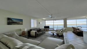 a living room with a couch and a table at Absolute Waterfront With Rooftop! in Caloundra