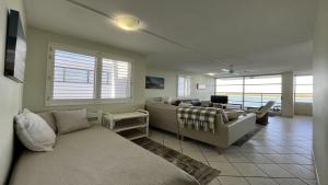 a living room with a couch and a table at Absolute Waterfront With Rooftop! in Caloundra