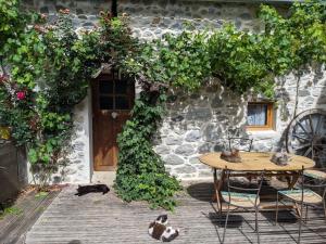 a table and chairs in front of a stone house at Chambres d'hôtes Les Chatougoulis in Les Bordes-sur-Lez