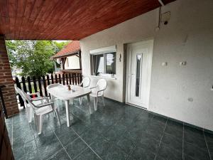 a patio with a white table and chairs on it at Arnold Apartmanház in Bük +12 photos