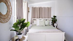 a bedroom with a white bed and a mirror at Blue Beach House in Caloundra +6 photos