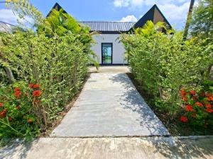 a pathway leading to a house with flowers at Thegrandstargoodview in Ban Na