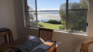 a dining room with a table and a large window at Sorrento Unit 5 in Golden Beach