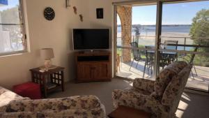 a living room with a television and a balcony at Sorrento Unit 5 in Golden Beach