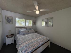 a bedroom with a bed and a ceiling fan at Spinnaker Seas Unit 8 in Caloundra +8 photos