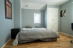 a bed in a bedroom with blue walls and wooden floors at Private Villa with parking - Skellefteå in Skellefteå