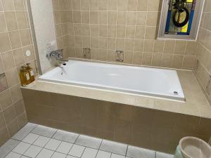 a bathroom with a white bath tub in a room at ホテルシルクロード ＡｄｕｌｔＯｎｌｙ in Hiroshima