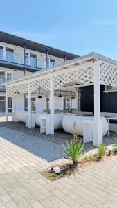a pavilion in front of a building with benches at Hotel Loft Кароліно-Бугаз in Zatoka