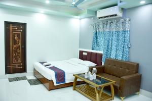 a bedroom with a bed and a couch and a table at S S Plaza in mayapur +23 photos