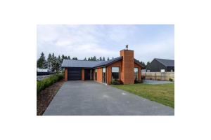 a house with a brick facade and a driveway at Gleniffer Views | Smart TV, Family Friendly, WiFi in Methven