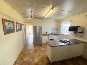 a kitchen with a stainless steel refrigerator and a sink at Bundi Hat Head - Bring your own linen in Hat Head +12 photos