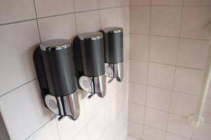 a row of silver and black paper cups on a wall at The Villa Kotoshiro -ヴィラ コトシロ- in Matsue