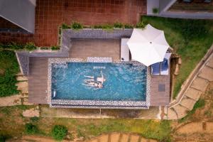 a person swimming in a pool with an umbrella at Ella 100 View Cottage in Ella