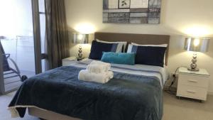 a bedroom with a large bed with towels on it at Amazing Views, Walk Everywhere! in Caloundra +7 photos