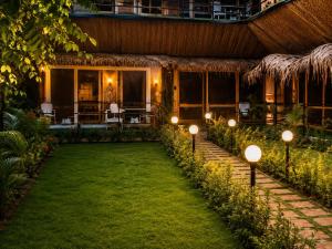 a garden with lights in front of a house at Basera At Palolem in Canacona