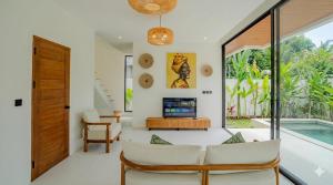 a living room with a tv and a pool at Santara Villa Ubud in Ubud