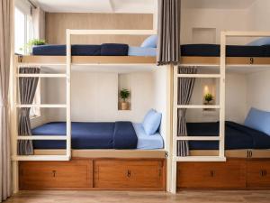 a room with bunk beds with blue pillows at Thiên Ngân Hostel in Da Lat +30 photos