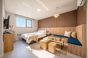 a bedroom with a bed and a couch and a table at Restia Hotel Suwon Station in Suwon