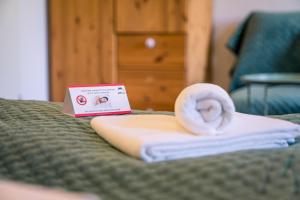 a hotel room with a towel and a book on a bed at Garni Hotel Zum Hothertor in Görlitz +66 photos