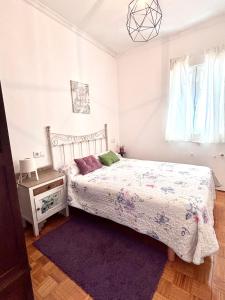 a white bedroom with a bed and a night stand at Apartamento en Monforte estación de tren in Monforte de Lemos