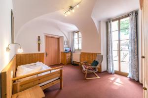 a bedroom with a bed and a chair in a room at Garni Hotel Zum Hothertor in Görlitz