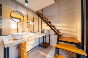 a bathroom with a sink and a mirror and a staircase at Restia Hotel Suwon Station in Suwon +69 photos