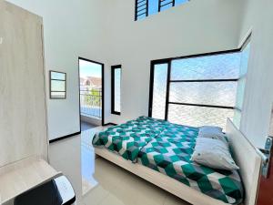 a bedroom with a bed and a large window at MP Villa Boulvard 43 Malang in Blimbing