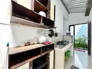 a kitchen with wooden shelves and a sink at MP Villa Boulvard 43 Malang in Blimbing