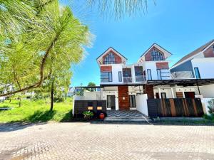 a house with a palm tree in front of it at MP Villa Boulvard 43 Malang in Blimbing