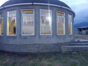 a round building with windows in a field at Кафе Кочевник in Chon-Sary-Oy