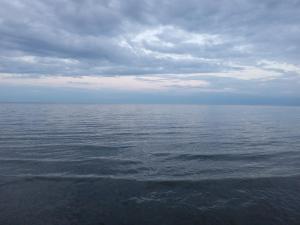 a large body of water with a cloudy sky at Кафе Кочевник in Chon-Sary-Oy