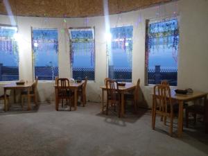 a room with tables and chairs in front of windows at Кафе Кочевник in Chon-Sary-Oy