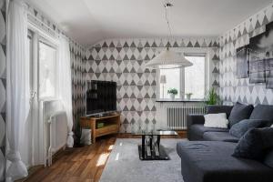 a living room with a couch and a tv at Private Villa with parking - Skellefteå in Skellefteå