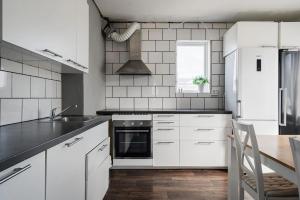 a kitchen with white appliances and a wooden table at Private Villa with parking - Skellefteå in Skellefteå +17 photos