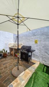 an umbrella sitting on a patio with a grill at Lefko House in Lachania