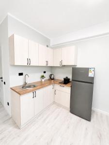 a kitchen with white cabinets and a stainless steel refrigerator at Saltanat hotel in Alghabas