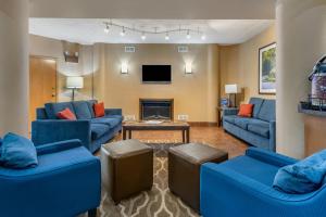 a living room with blue couches and a tv at Comfort Inn West Hazleton in West Hazleton