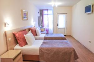 a hotel room with two beds and a couch at Hotel Acropolis in Varna City +100 photos