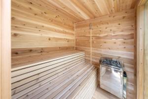 a wooden sauna with a bench in the middle at Spa & Riverside - Le Ptit Cool Des Bois in Trois Rives