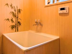 a large bath tub in a bathroom with a plant at 忍 Shinobi House in Yokohama +48 photos