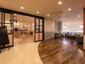 a living room with a couch and a table at Comfort Hotel ERA Kobe Sannomiya in Kobe
