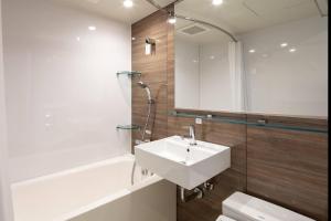 a bathroom with a sink and a tub and a toilet at Comfort Hotel ERA Kobe Sannomiya in Kobe +37 photos