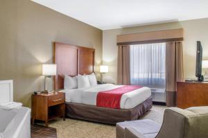 a hotel room with a bed and a window at Comfort Inn & Suites Covington - Mandeville in Covington